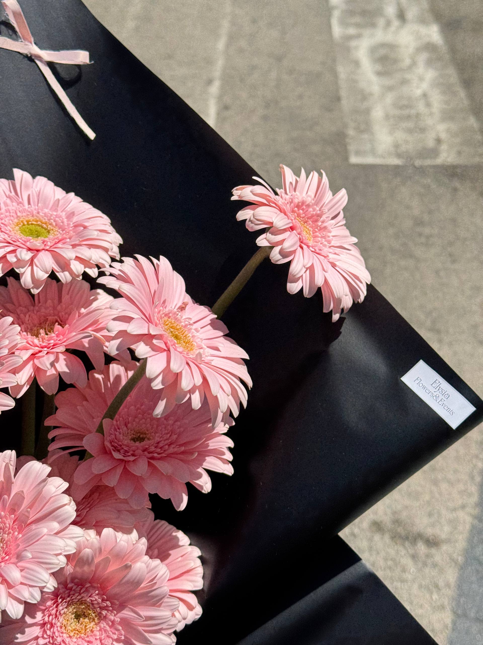 Pink flowers on a black box with a blurred background Flores rosadas en una caja negra con un fondo borroso