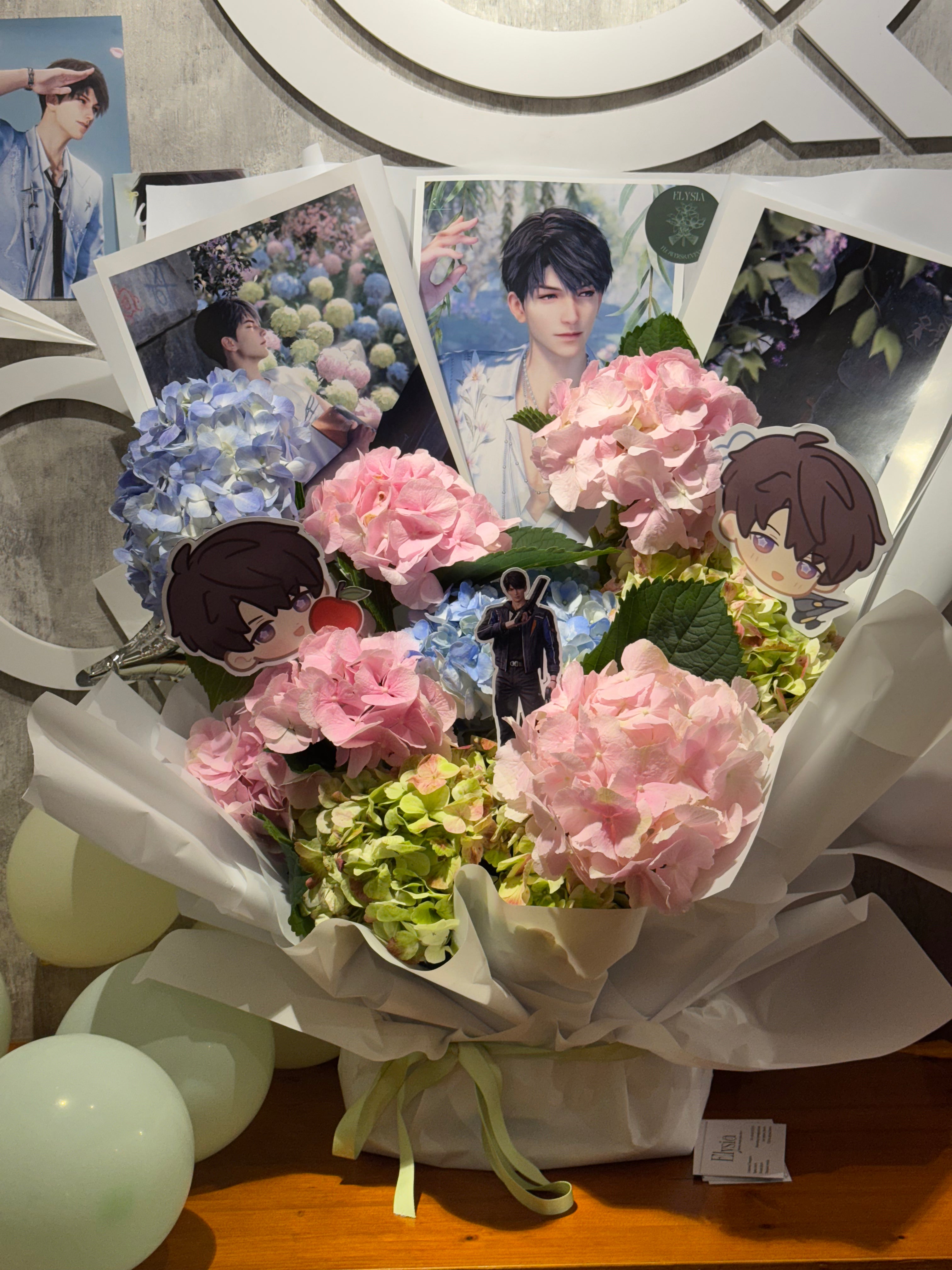 Bouquet of flowers with cartoon character figurines and photos on a decorative stand. Ramo de flores con figuritas de personajes de dibujos animados y fotos en un soporte decorativo.